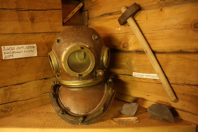 Martti Matilaisen sukeltajankypärä, kivihakku sekä pari kromimalmilohkaretta Keminmaan kotiseutumuseossa.